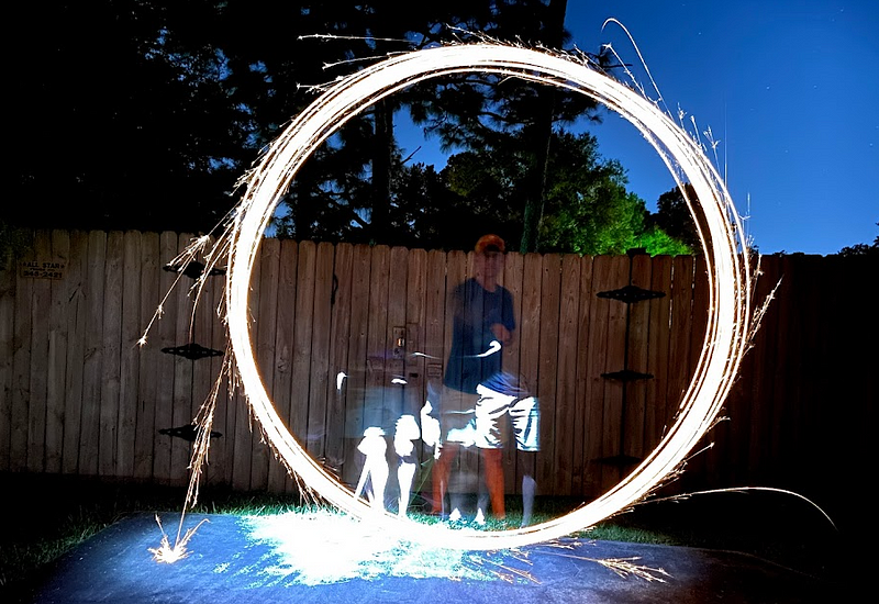 Long exposure photo of a sparkler creating artistic light trails.